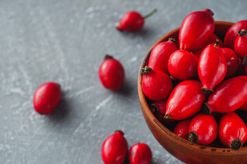 fresh red rose hips on a stone background