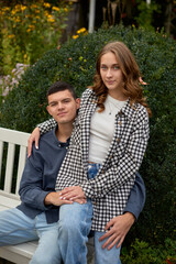 Fototapeta premium Young Cute Female Hugs Boyfriend. In Autumn Outdoor. Lovers Walking in Park. Attractive Funny Couple. Lovestory in Forest. Man and Woman. Cute Lovers in the Park. Family Concept. Happy Couple.