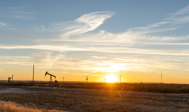 Oil wells in Texas early in the morning with sunrise in background
