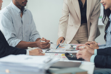 Business Meeting Analysis: A diverse team of business professionals gather around a table,...