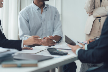 Obraz premium Collaborative Discussion: A diverse team of business professionals engages in a collaborative discussion, focusing intently on documents, ideas, and strategies.