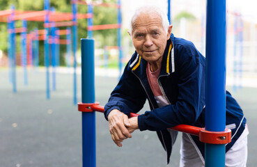 Obraz premium Old man in outdoor workout station