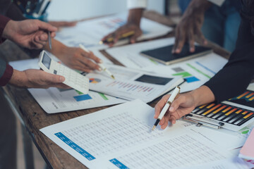 Data Driven Decisions: Close-up of a team's hands engaged in analyzing financial data, showcasing collaboration and strategic planning in a modern business environment.