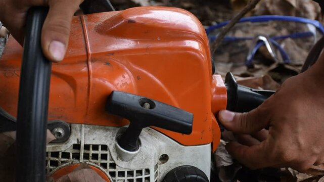Lumberjack Starting Chainsaw, Woodcutter Igniting Chainsaw, Forestry Worker Preparing Chainsaw. High quality 4k footage