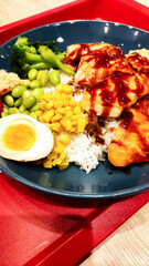 Savoring teriyaki chicken rice bowl topped with boiled egg, featuring colorful vegetables for romantic prague dining experience