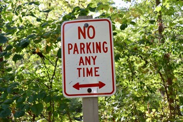 A close view of the red and white parking sign.