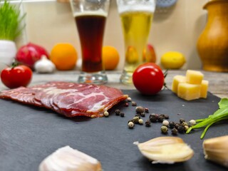 Thin slices of bacon lie on a sliced board in the background of a beer tank