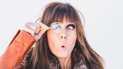 Ein Frau mit brünetten Haare schaut durch eine Lupe