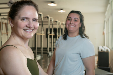 Pilates trainer and her student similimg on a Pilates class.