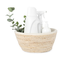 Eco-friendly cleaning products and eucalyptus branches in wicker basket isolated on white