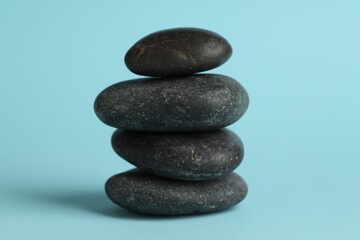 Stack of rocks on light blue background. Harmony and life balance
