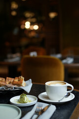Cup of coffee, bread, and pastries on a black table. Morning Coffee and Bread. Breakfast Spread