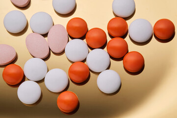Colorful pills on a golden background.