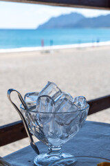 Glass of cold water with ice on the beach Italy