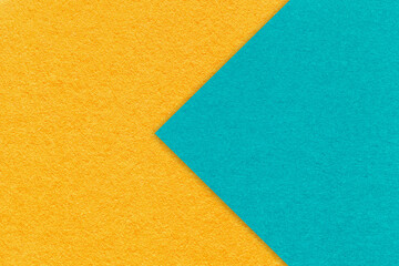 Texture yellow paper background, half two colors with turquoise arrow, macro. Structure craft cerulean cardboard.