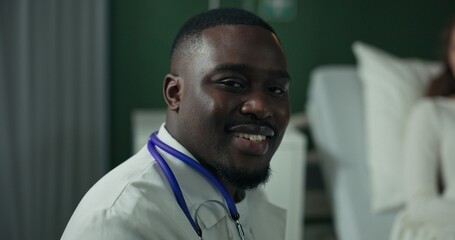 Young African American physician arrives to talk with the patient about her treatment plan.