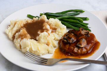 salisbury steak top with gravy, onions andmushrooms