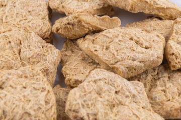 Dried soy meat pieces on a white plate. textured vegetable protein.