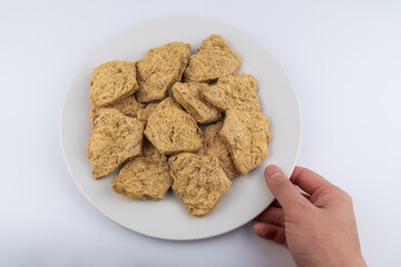 Dried soy meat pieces on a white plate. textured vegetable protein.