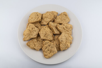 Dried soy meat pieces on a white plate. textured vegetable protein.