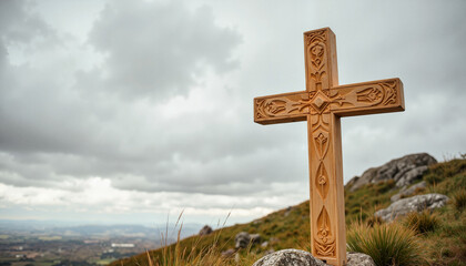 Intricately carved wooden cross on hilltop under dramatic skies, spirituality