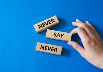 Never say Never symbol. Concept words Never say Never on wooden blocks. Businessman hand. Beautiful blue background. Business and Never say Never concept. Copy space
