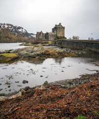 Eilean Donan Castle with bridge under a grey clouded sky in Scotland