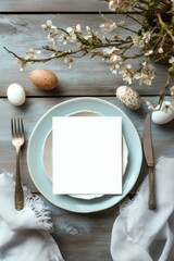 Easter dinner table setting with blank card, eggs, and spring blossoms