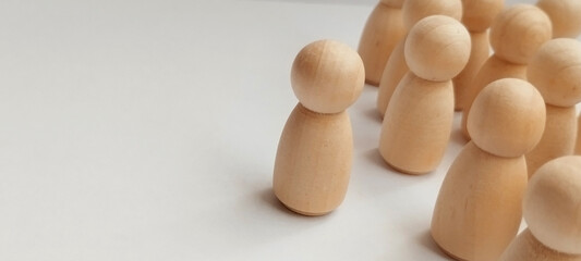 Leadership dynamics wooden figurines representing group behavior studio photography neutral background conceptual focus