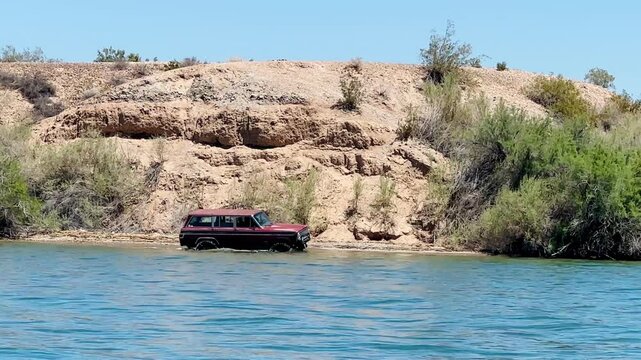 An adventurous off-road truck navigates Lake Havasu's flooded shoreline, circumventing inaccessible areas and showcasing a unique exploration of Arizona's popular waterfront playground.