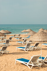 Empty deck chairs on the sandy beach by the beautiful sea.