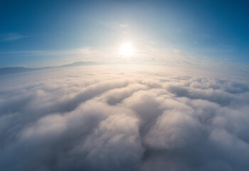 Sunrise over fluffy cloudy with foggy and blue sky