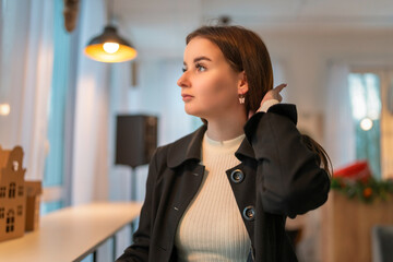 Portrait of a young beautiful dark-haired girl in a cafe.