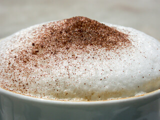Close up of the frothed milk and cocoa powder in cappuccino coffee drink