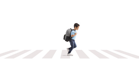 Full length profile shot of a schoolboy running with a backpack at a pedestiran crossing