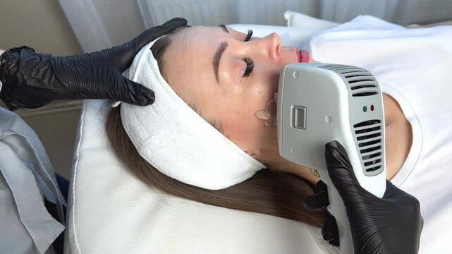 Anti-aging procedures footage. Woman receiving facial beauty treatment, removing pigmentation at cosmetic clinic. Phototherapy, photorejuvenation, IPL in a beauty salon. Skin care concept. 
