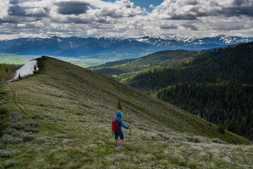 Obraz premium USA, Idaho. Woman hiking in Big Hole Mountains with view of east side of Teton Mountains