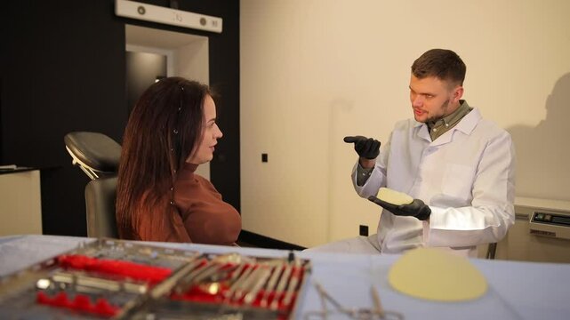 Breast augmentation specialist discussing different treatment options with patient in modern clinic