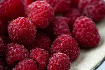 A close-up of fresh, juicy raspberries, showcasing their vibrant red color and fine details, perfect for healthy snacks or desserts.