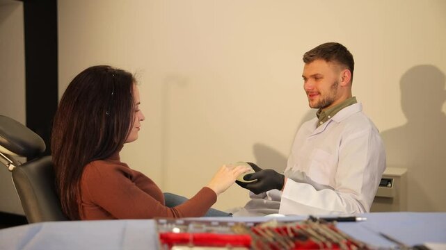 In a modern clinic, a doctor thoughtfully discusses various breast augmentation treatment options with a patient.