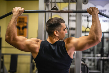 Fototapeta premium young muscular man do exercise for chest on the exercise cable machine