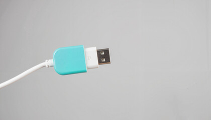 Fototapeta premium USB adapter in turquoise and white against gray background, tech utility