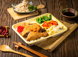 Crispy Chicken Leg Bento with steamed rice and salad served in tray isolated on wooden background side view of taiwan food