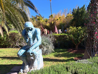 Contemplative Sculpture Nestled Among Lush Greenery in a Tranquil Garden Setting