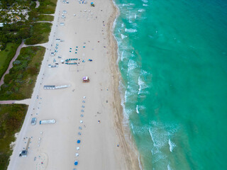 Sea relax under beach umbrella. Travel to sea. Aerial top view of sand beach with crystal clear turquoise water. Summer vacation in paradise. Beach vacation at sea in summer. Miami beach