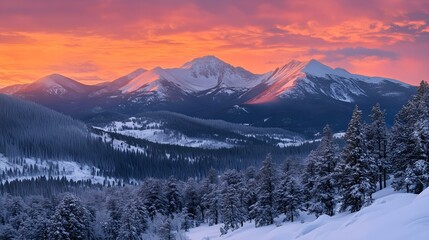 Fototapeta premium Majestic snow covered mountains at sunset with a colorful sky and evergreen trees in a serene winter landscape