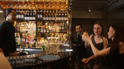 Couple talking at sitting bar with Margarita cocktail savoring sour tasty drink in happiness moment meeting while woman waiting friends at front view at luxurious counter vibrant nightclub. Vinosity.