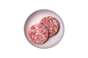 Fresh raw ground beef or pork burger patty with salt and spices