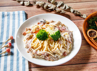 white sauce pasta with bacon and broccoli served in plate isolated on wooden table side view of taiwan food