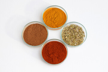 Various spices in a petri dish, white background